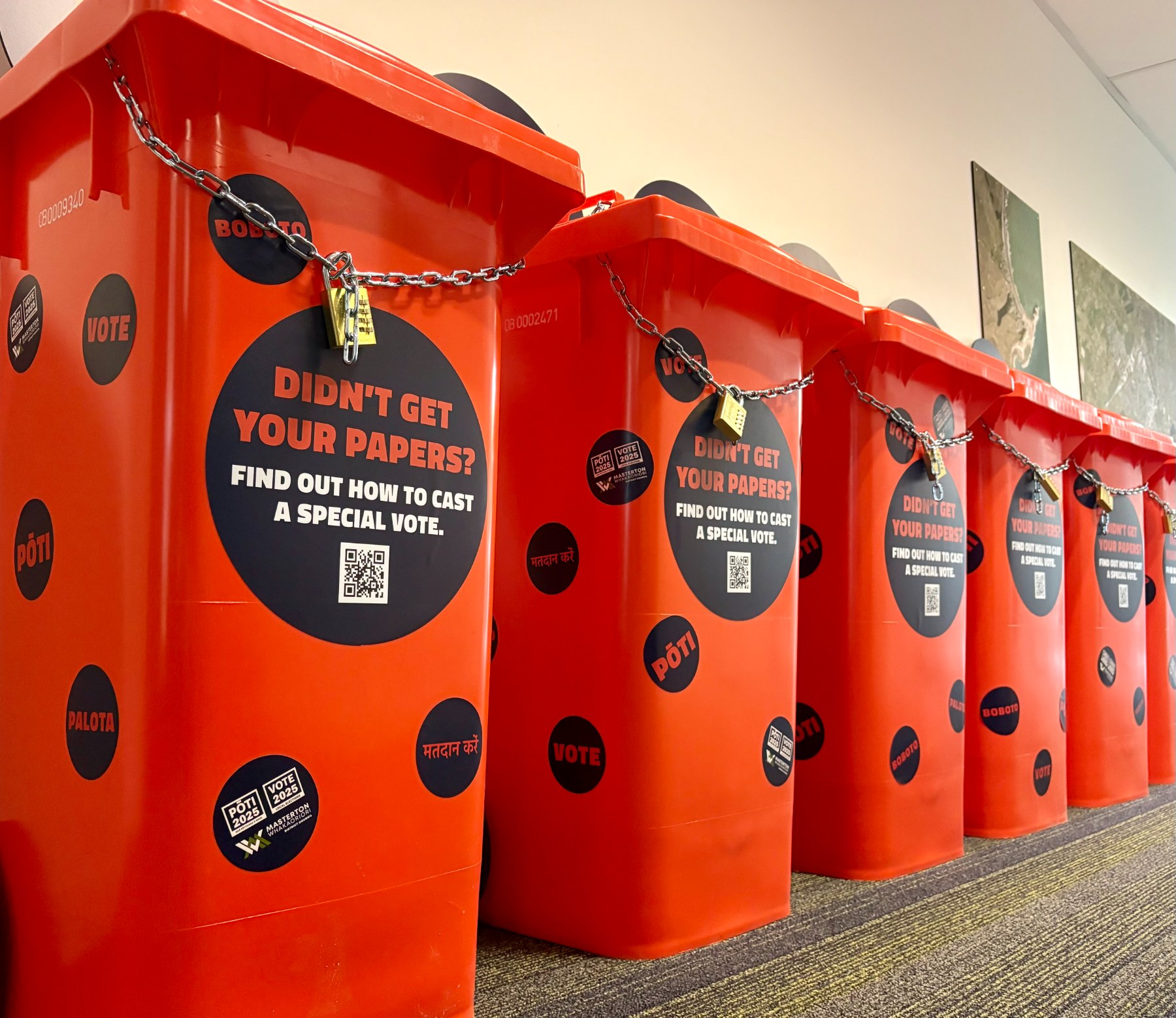 Spotty orange wheelie bins lined up with chains and padlocks